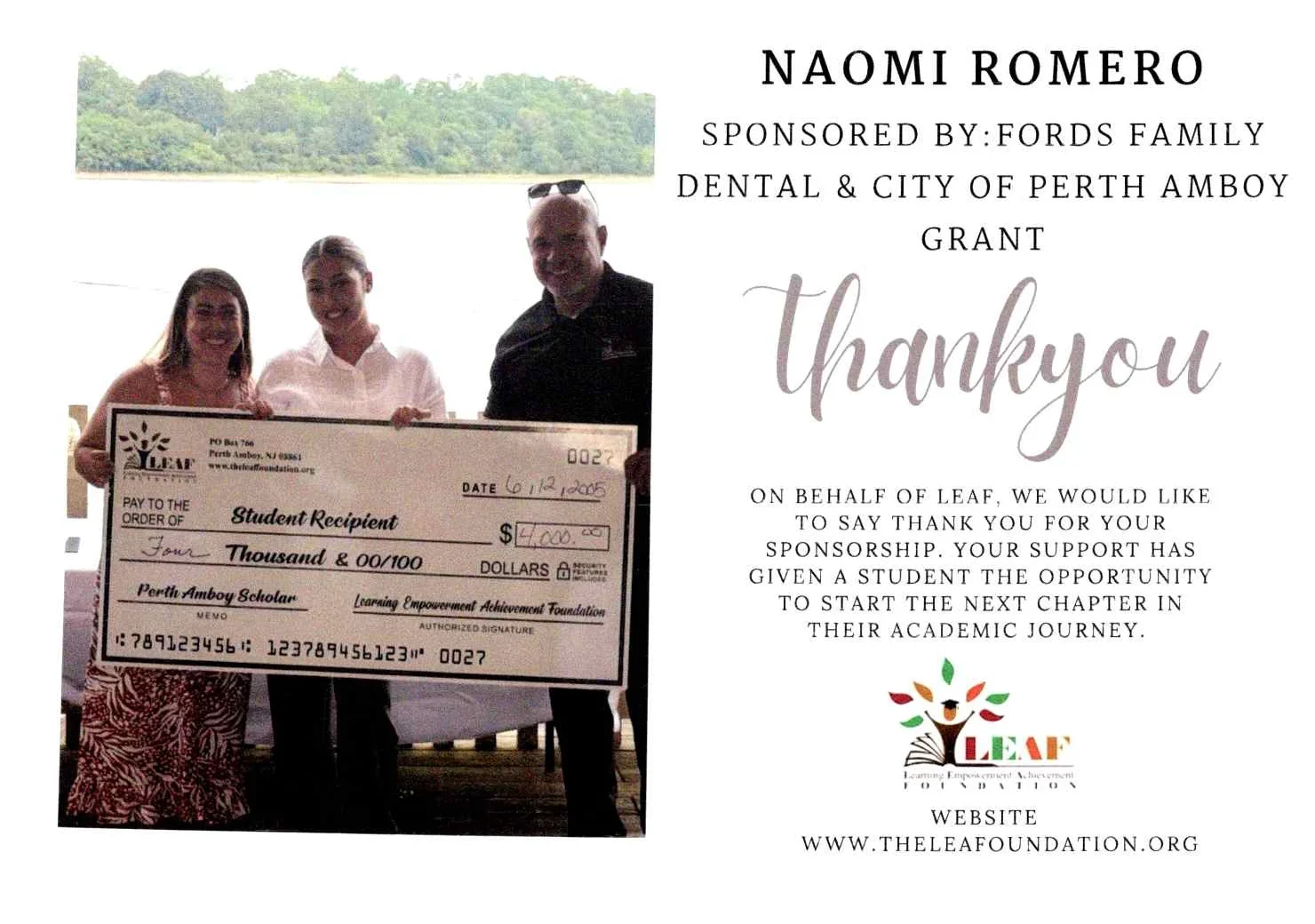People standing holding a large check